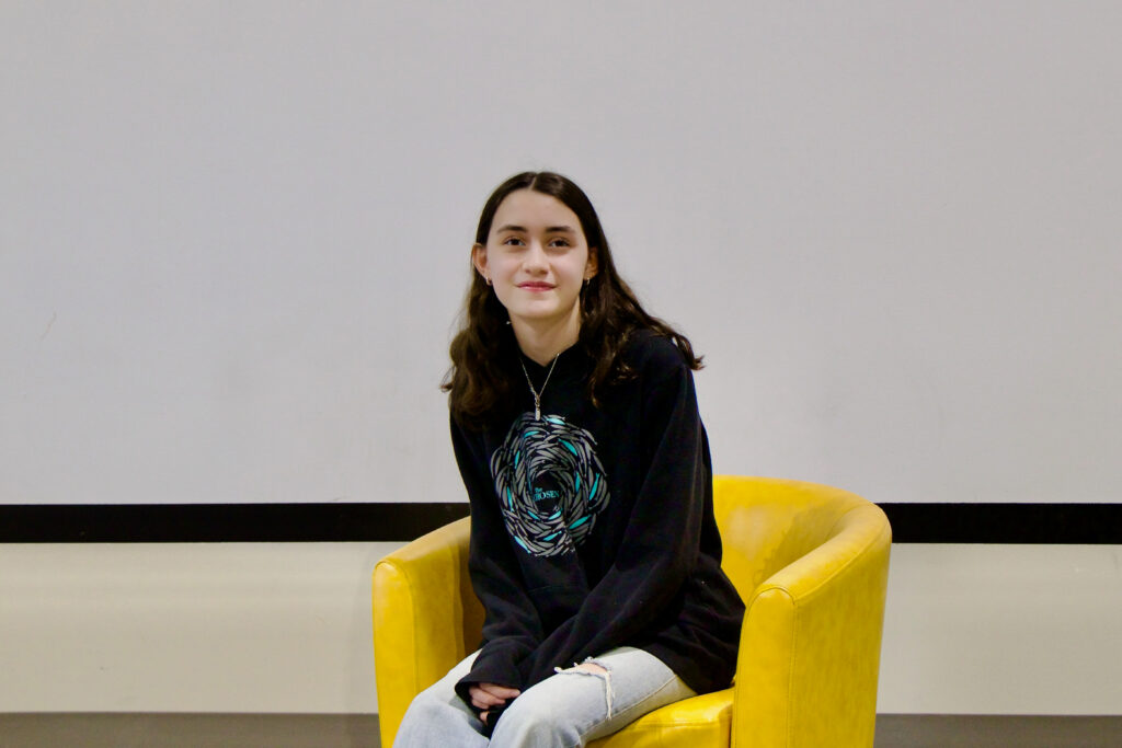 Danielle Heimlich, 2026 CenterPoint Scholar, sits leaning slightly forward in a yellow arm chair.