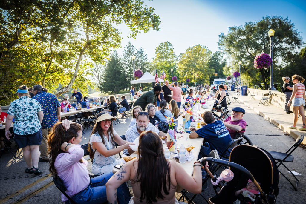 Muncie residents socialize at long tables set up on the Washington Street Bridge